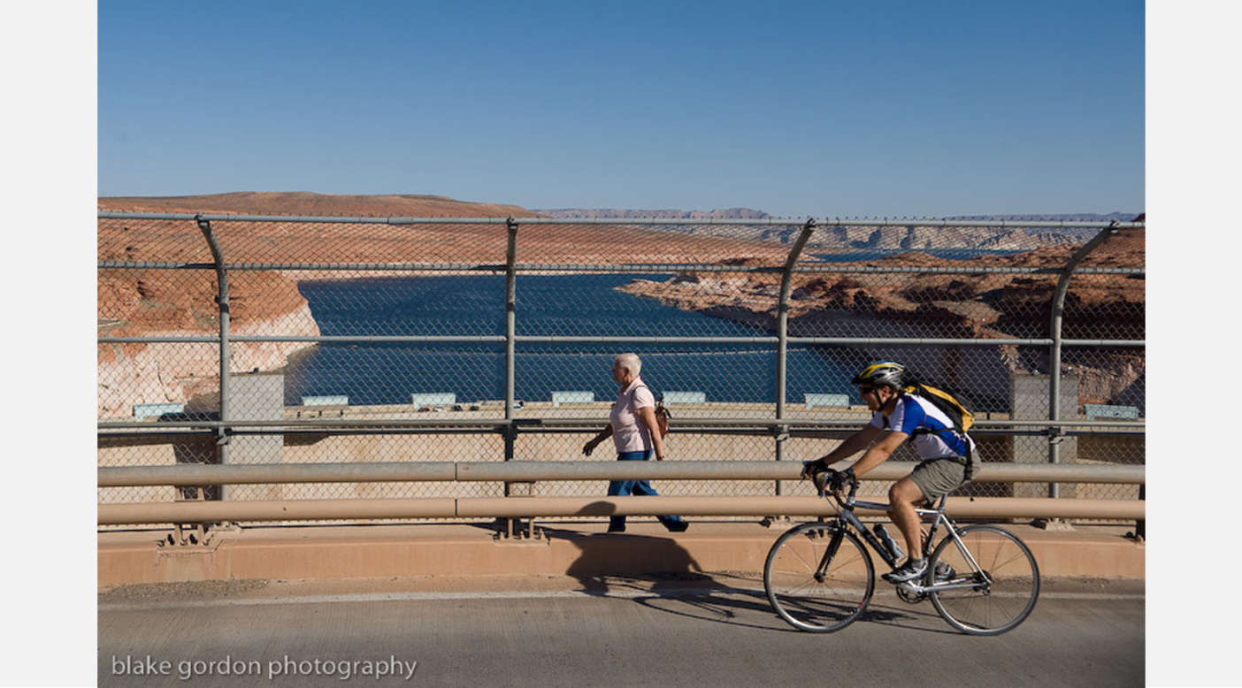 Lin Alder crosses the Glen Canyon Dam bridge on the opening day of the Lake Powell Pipeline Trek. Alder and Scott Hirschi went on an 8 day trek along the route of the proposed Lake Powell Pipeline to generate community discussion. Photo: Blake Gordon.