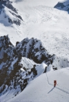 One of my partners descends from Camp III. The precarious perch of Camp II, where the team excavated a small ledge from a cornice, can be discerned at the high point of the serrated ridge below. You can make out much of the trail of climbing along the jagged ridgecrest. Photo: Allen Steck