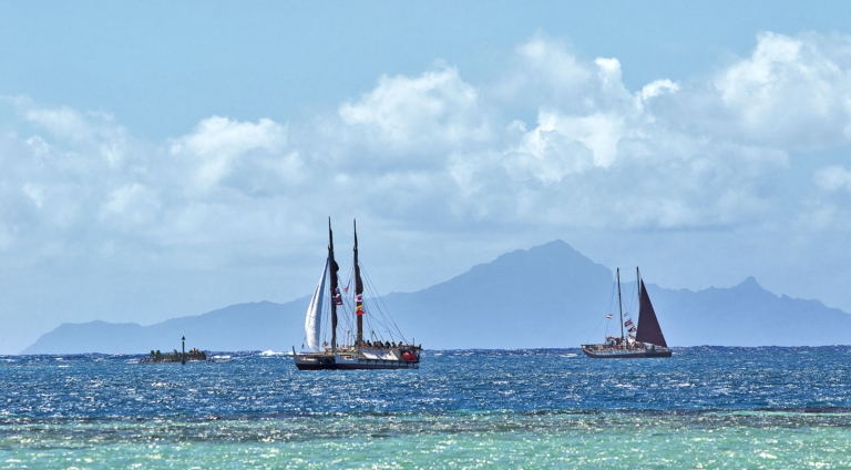 With the wind in the high twenties and minimal sail up, Hōkūle‘a and Hikianalia sail into Te Ava Mo‘a, the Sacred Pass to Taputapuātea. Photo: John Bilderback