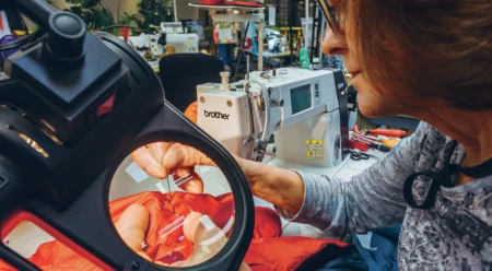 Susan Baker repairs a jacket that might just belong to her daughter, whom she raised skiing in the nearby Sierra. Photo: Ken Etzel