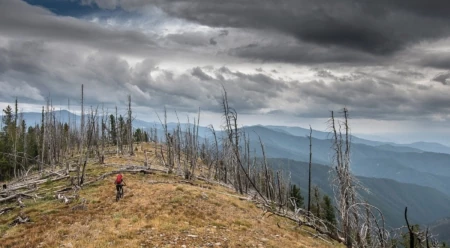 Chris Shalbot races the weather above Big Hole Pass as foreboding clouds gather in the distance. Photo: Scott Rinckenberger