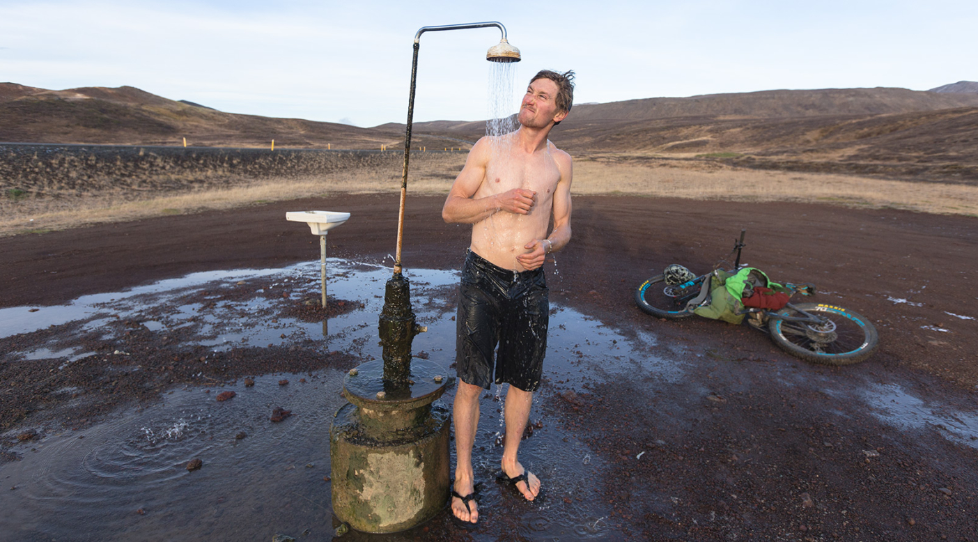 After a finger-numbing ride through the highlands, Carston can’t quite believe his luck as he warms up under one of Iceland’s most luxurious natural amenities—unlimited hot water from underground geothermal fields. Photo: Mary McIntyre