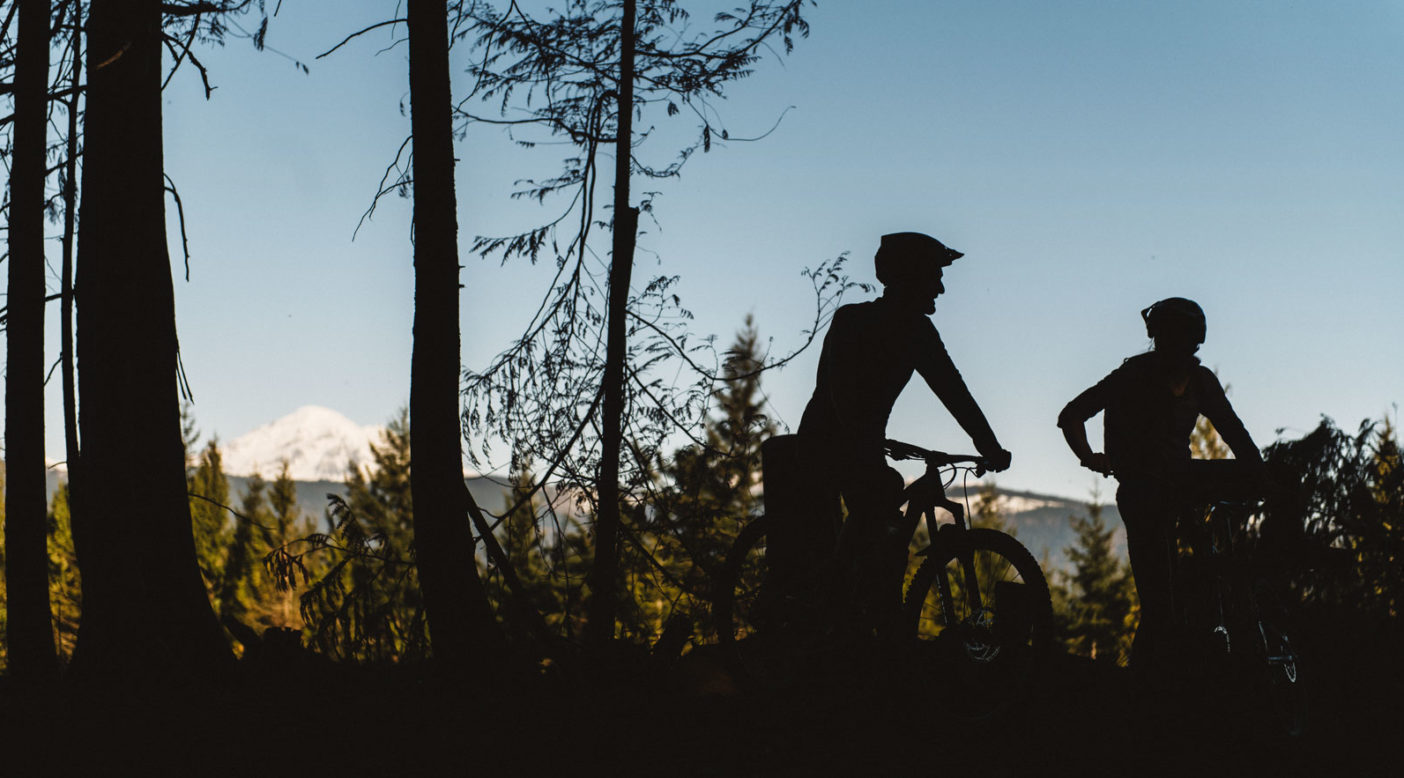 With Mount Baker peeking over the horizon, Mark Allison (left) and Bonnie Burke (right) get ready to drop in on SST, a Galbraith classic. Photo: Paris Gore