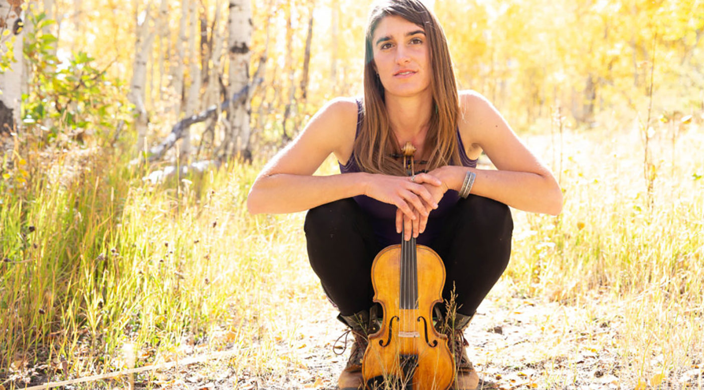 Lizzy Plotkin amongst the aspens with her Lackey five-string fiddle. Photo: Lydia Stern
