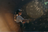 A person casting their fly rod with light reflecting on the lens of the camera.